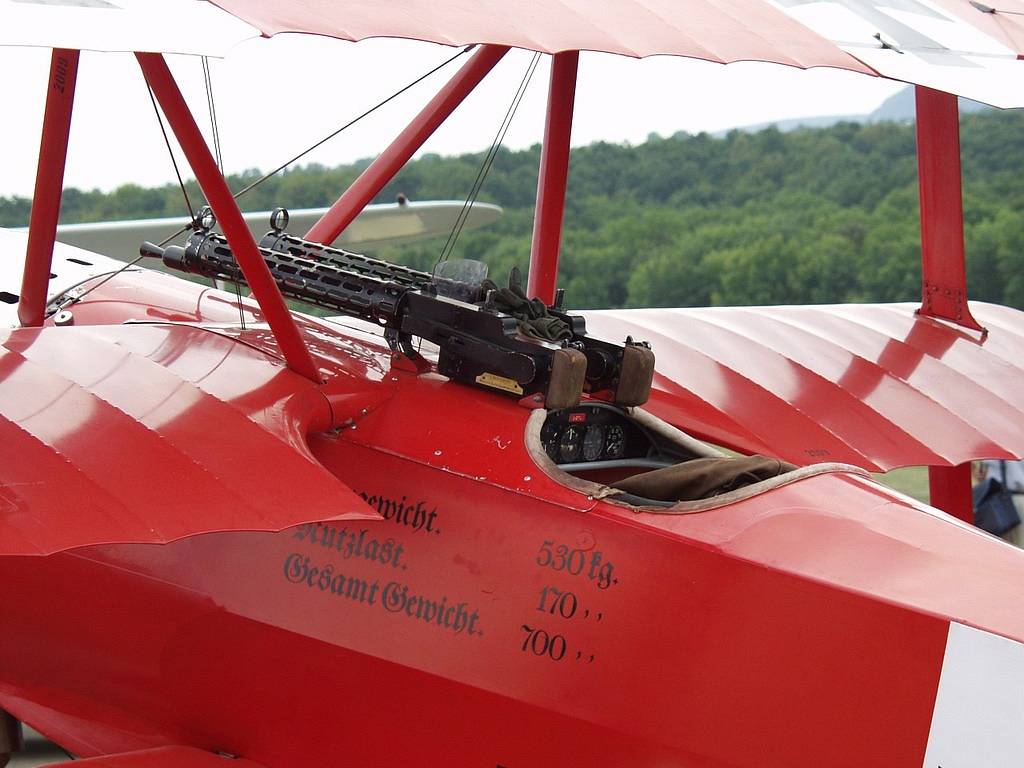 A red airplane with a machine gun mounted to it's wing. Triplane fokker dr1 the red baron.