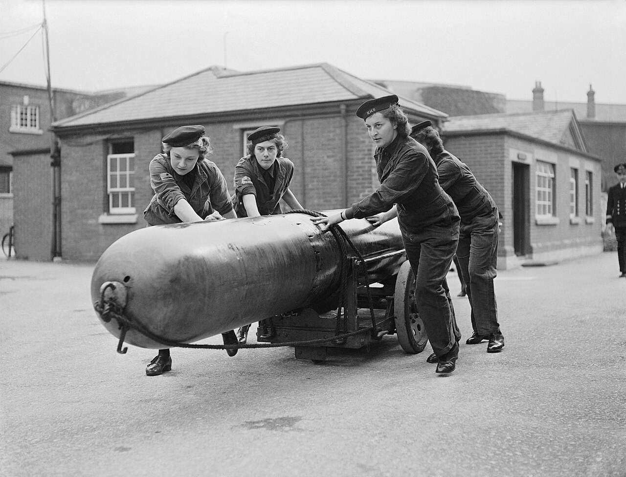 Members of the Women's Royal Naval Service (WRNS) move a torpedo for loading into a submarine at Por