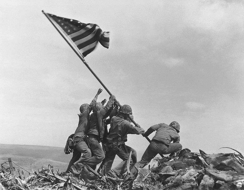 American soldiers wading ashore during D-Day landing at Normandy beach, June 1944, iconic World War II photograph.