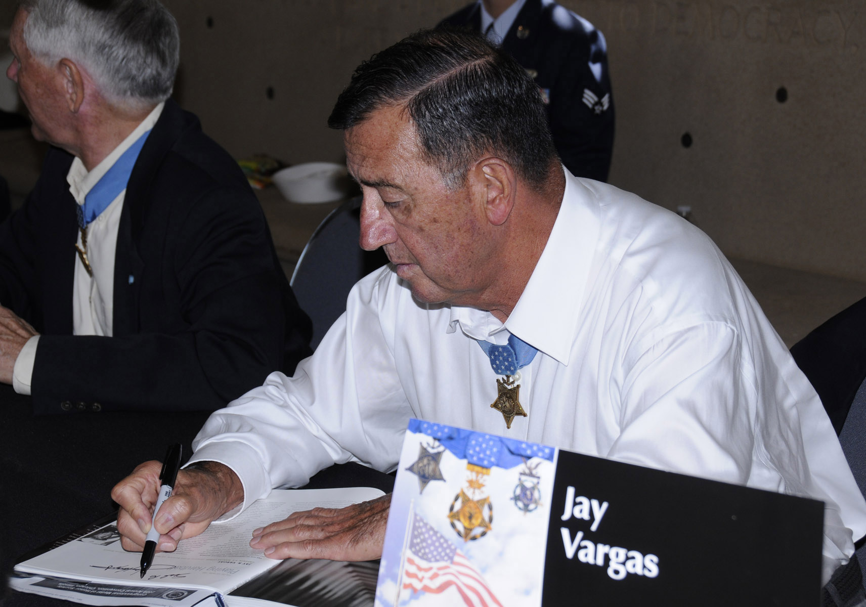 Jay Vargas autographs a book in 2009.jpg