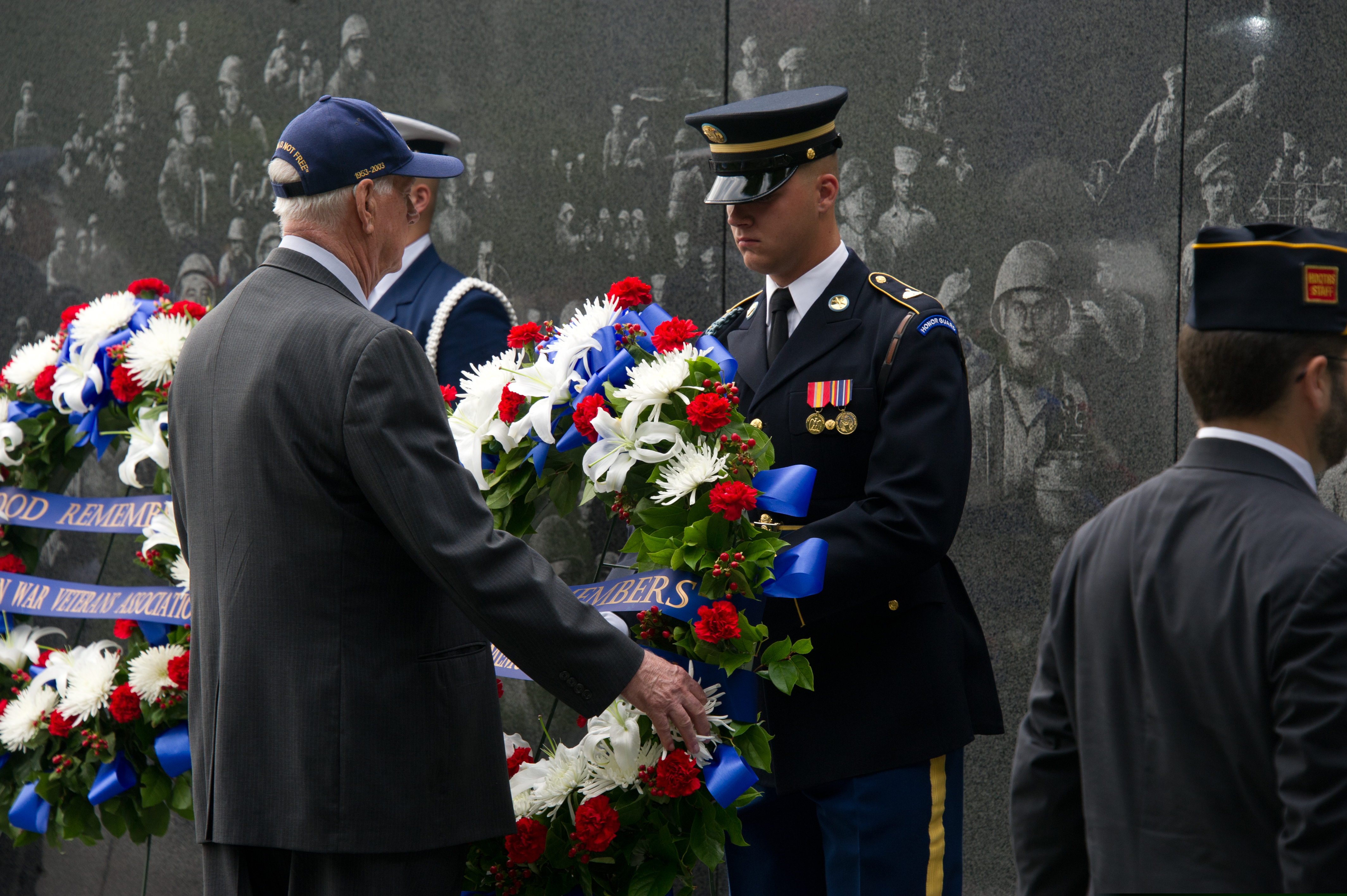 A Korean War veteran, left, places a wreath during an event marking the 60th anniversary of the Kore