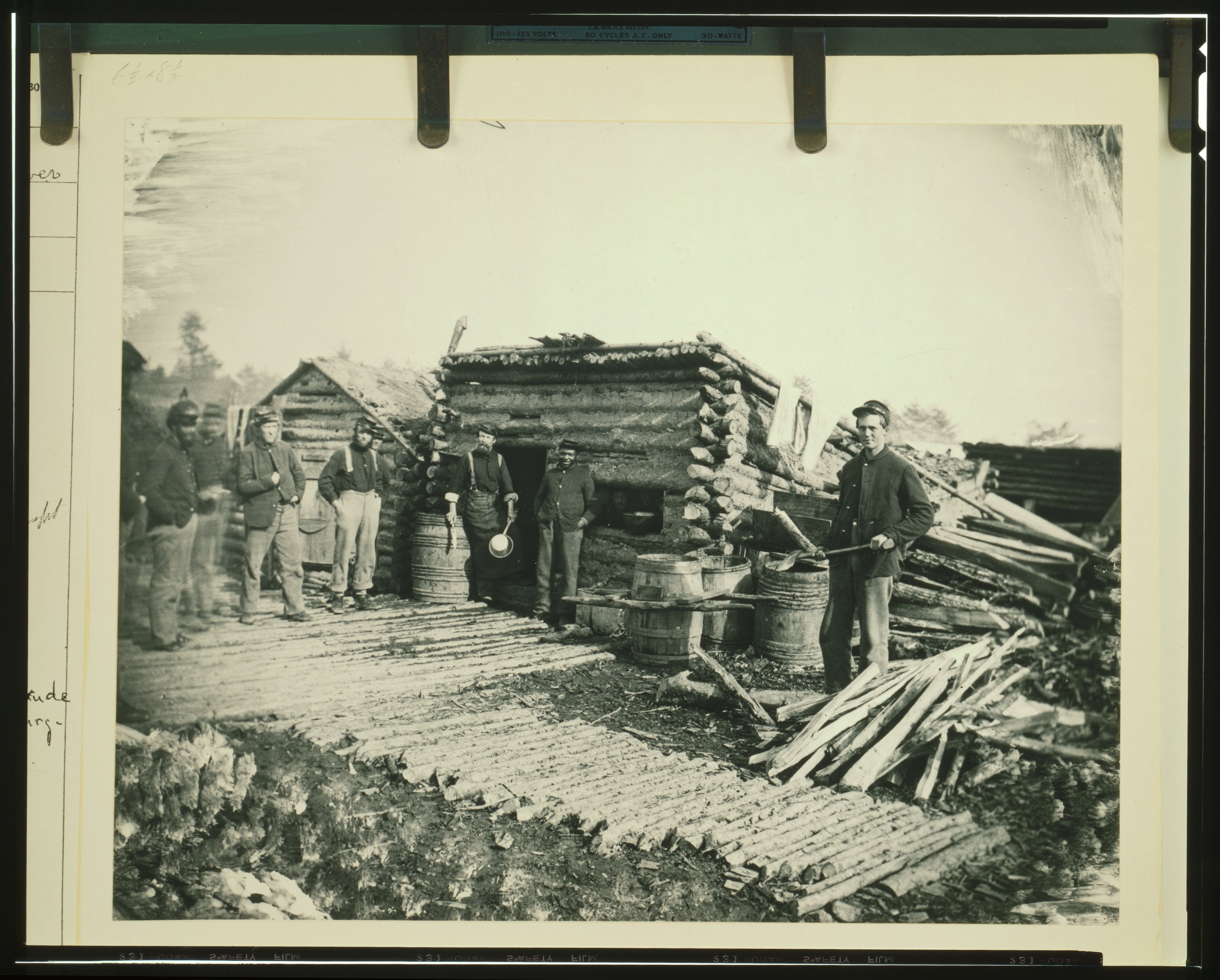Civil War camp of the 6th N.Y. Artillery at Brandy Station, Virginia, showing Union soldiers in front of log company kit
