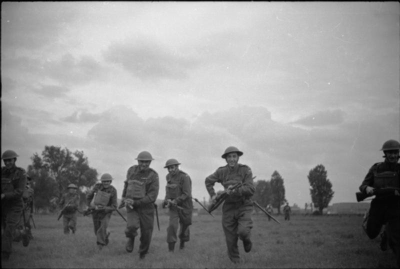 Soldiers disembarking from landing craft onto beach during D-Day invasion, June 1944 Normandy amphibious assault.